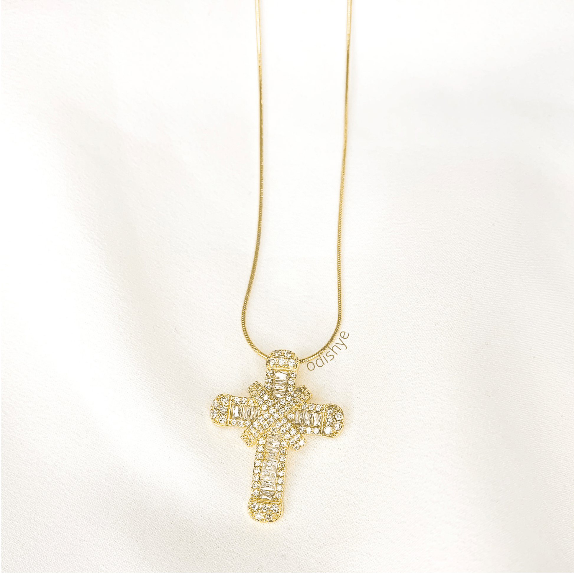 This dazzling cross-over necklace is lined with cubic zirconia. This not so- subtle piece sparkles beautifully in the light. It is an elegant yet bold piece that is perfect for everyday wear. 